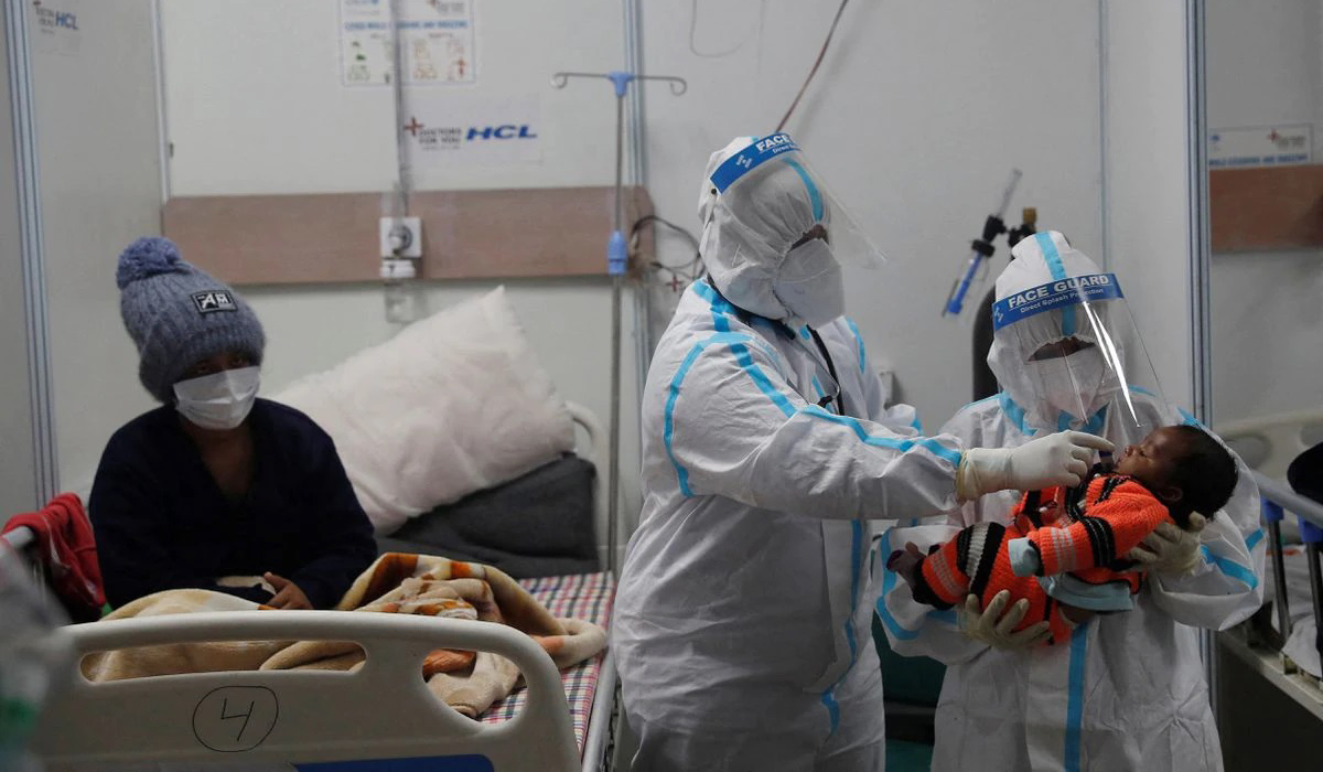 Medical workers check temperature of an infant